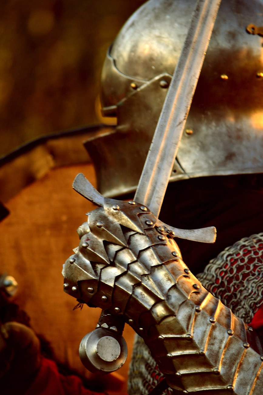 suit of armor with helmet, hand and sword visible.